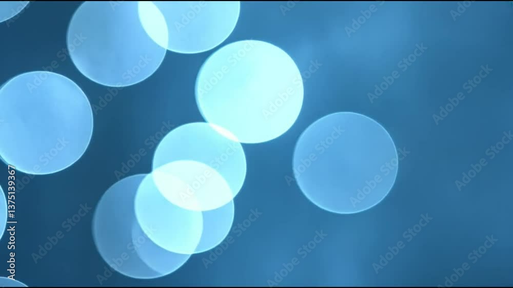 Cool-toned blue and silver bokeh circles shifting in a misty background