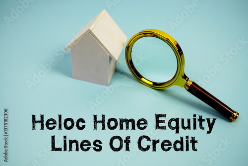 HELOC Home Equity Lines Of Credit text with White Model House and magnifying glass on blue background
 photo