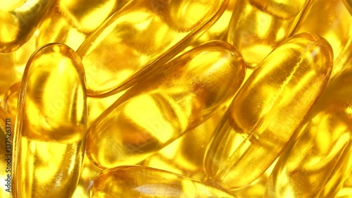 Fish oil capsules with omega 3 and vitamin D on white background, close up, rotates. Golden fish oil in gelatin capsules