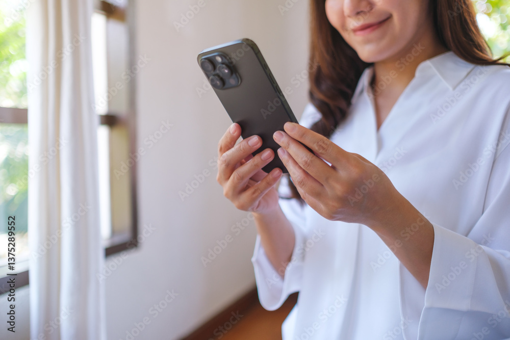 Closeup image of a woman holding and using mobile phone at home Closeup image of a woman holding and using mobile phone at home