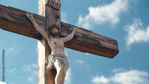 Crucifixion of Christ against the sky background. Catholicism, Christianity, faith concept. The initialism INRI Iesus Nazarenus, Rex Iudaeorum represents the Latin inscription in English translates to photo