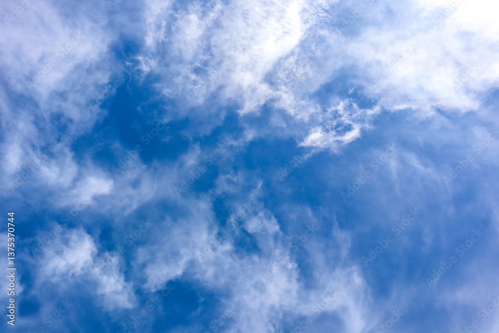 Blue sky with soft white clouds. Peaceful natural view.