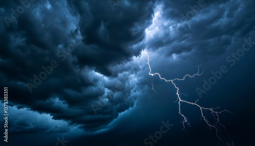 A summer thunderstorm with heavy rain gusty winds and flashes of lightning brightening the dark clouds. Fierce storm bright sky.