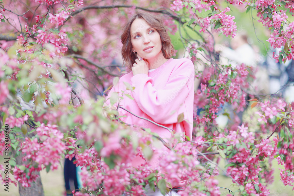 Springtime background, a woman in pink in a blooming cherry orchard, a model posing in a romantic style Springtime background, a woman in pink in a blooming cherry orchard, a model posing in a romantic style