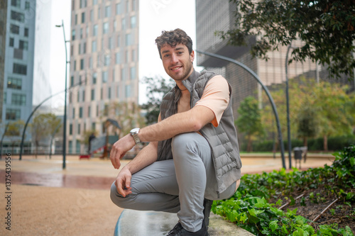 Photography Young man smiling and crouching in a city park