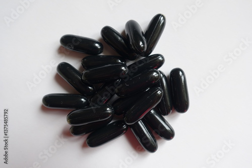Obraz na płótnie Closeup of heap of black softgel capsules of activated charcoal w salonie