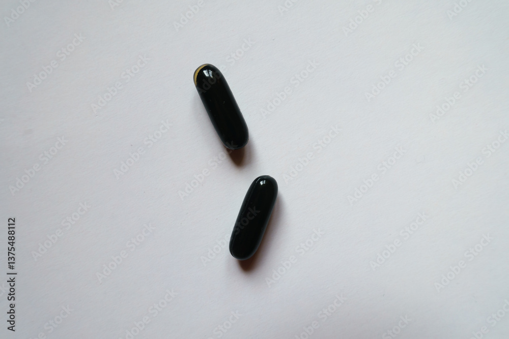 black softgel capsules of activated charcoal from above (two items)
