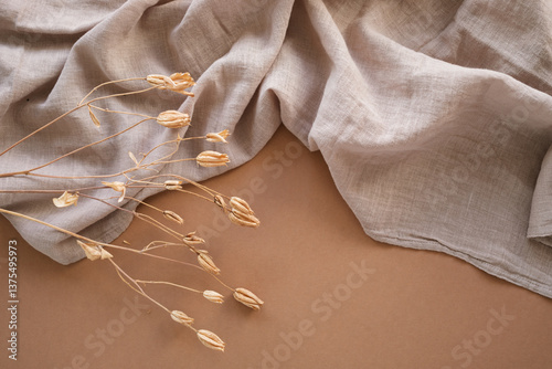 Close-up overhead view of a decorative dried plant on a piece of linen fabric on a table photo