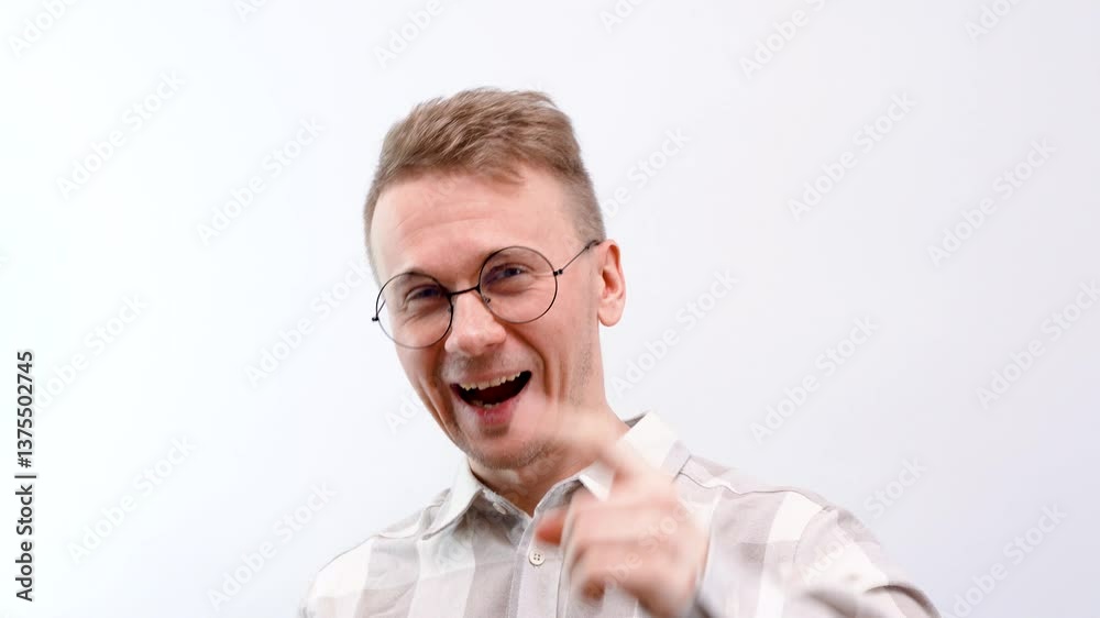 A cheerful man in funny round glasses rejoices at a new idea and successful plans A cheerful man in funny round glasses rejoices at a new idea and successful plans