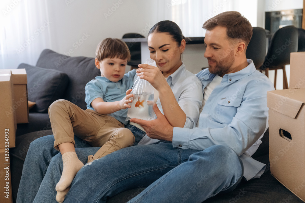 On the sofa, sitting and relaxing. Family of husband, wife and son are moving into new house On the sofa, sitting and relaxing. Family of husband, wife and son are moving into new house