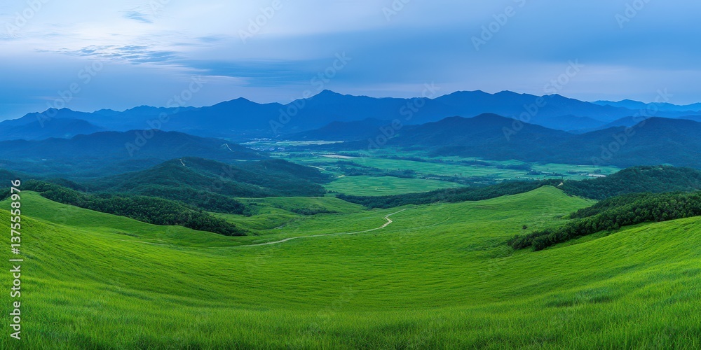 Fototapeta premium Rolling green hills and winding valley river under blue sky. Wide panoramic landscape with distant mountains. Calm optimism and renewal. Ideal for travel marketing, sustainability