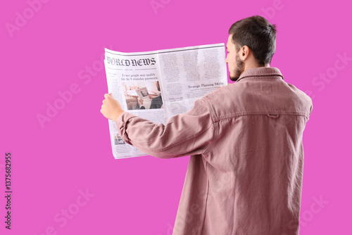 Young man reading newspaper...