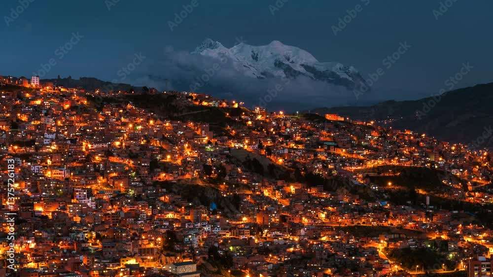 Day to night timelapse of La Paz cityscape and Illimani mountain in Bolivia, South America, zooming in. 

