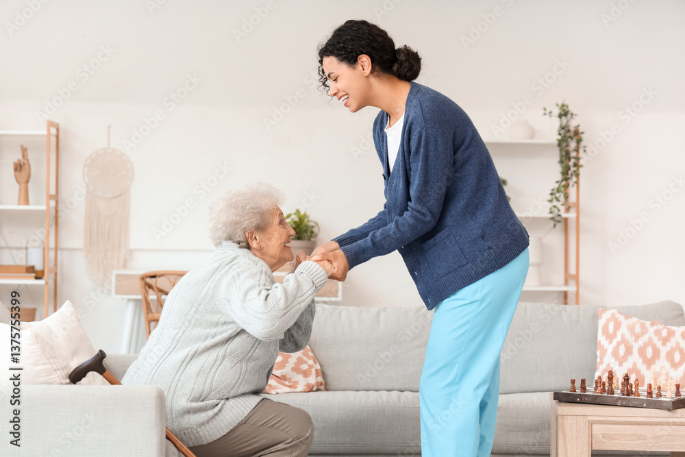 Φωτογραφία Young African-American female medical worker helping elderly woman in nursing ho