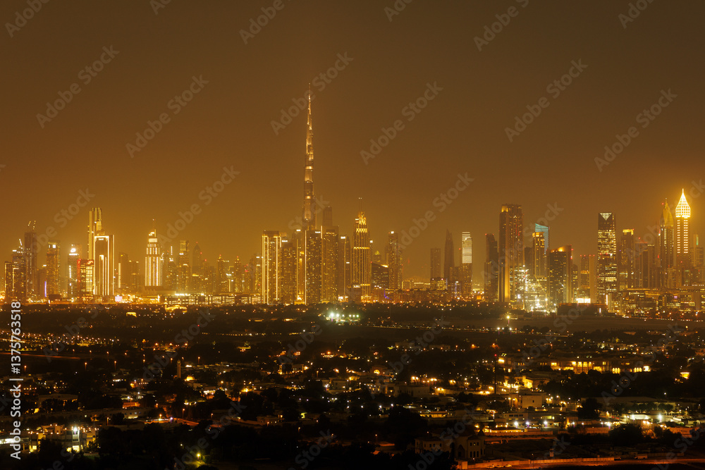 Fototapeta premium Nightscape of Dubai, featuring the majestic Burj Khalifa towering above an array of sparkling skyscrapers.