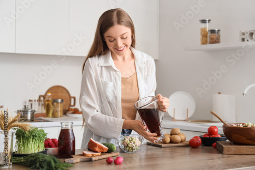 Young woman pouring kvass i...