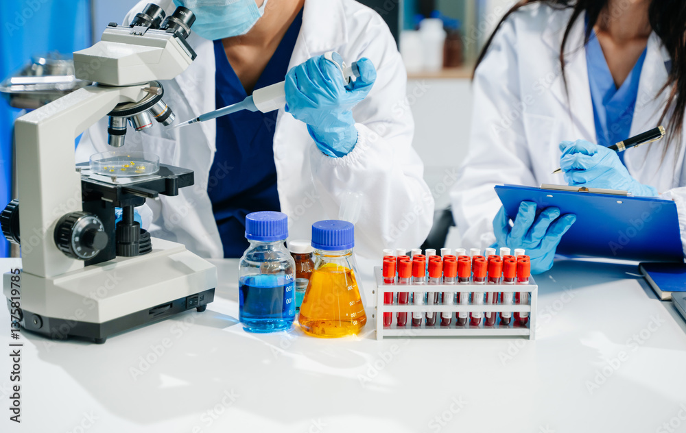Fototapeta premium scientists in lab coats conducting research, handling glassware, and working with chemicals