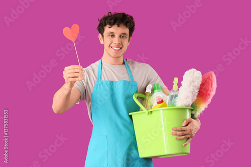 Happy male janitor with buc...