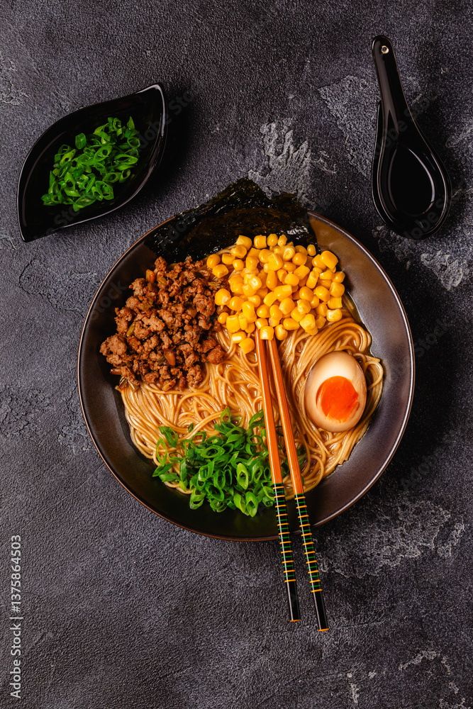 A bowl of ramen with noodles, meat and green onions.