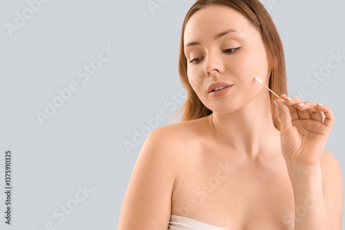 Young woman with cotton bud...