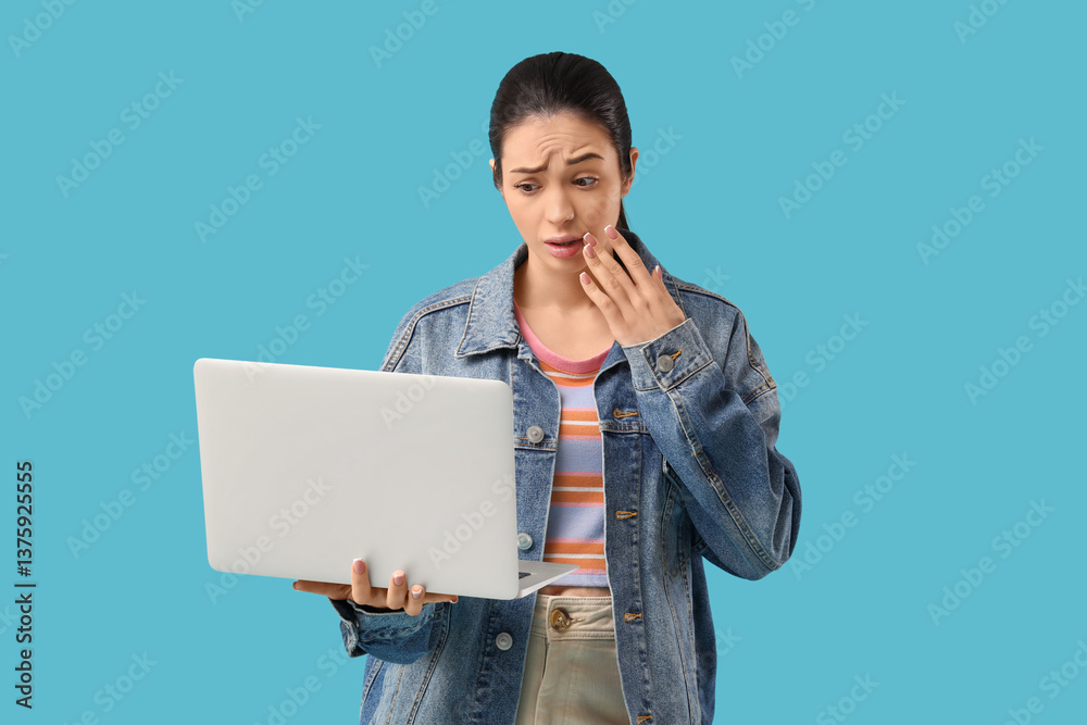 Shocked young woman with laptop on blue background Shocked young woman with laptop on blue background