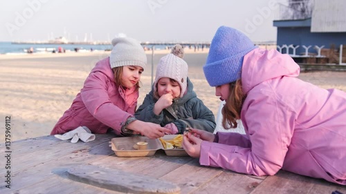 Caucasian Kids Eating Fried Fish and Chips French Fries Fast Food Snack in Styrofoam Box Sold at Seaside Beach Bar