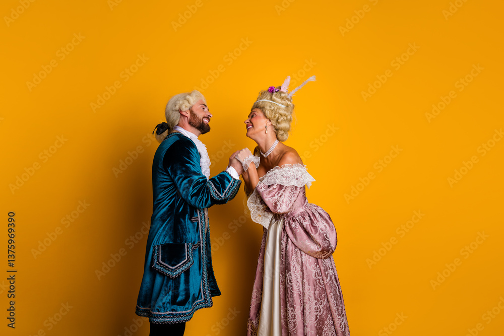 Fototapeta premium Couple in elegant historical costumes sharing a joyful moment against vivid yellow backdrop