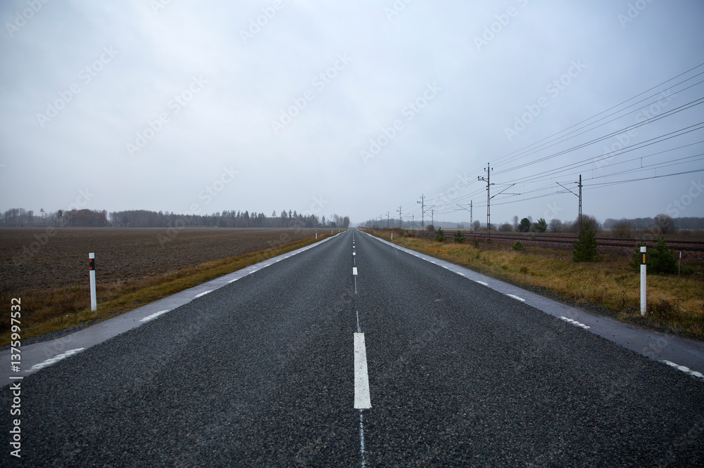 Straight empty road against cloudy sky Straight empty road against cloudy sky