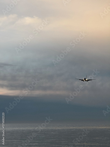 Obraz na płótnie Airplane Approaching Over Calm Ocean at Dusk w salonie