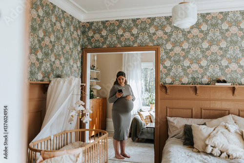 Reflection of pregnant young woman using smart phone at home photo