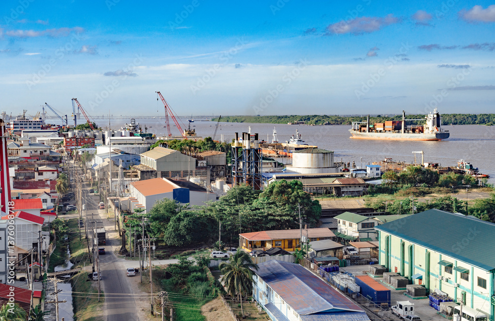 Georgetown, Guyana with industrial activity along the waterfront of the Demerara River and a cargo ship in the background