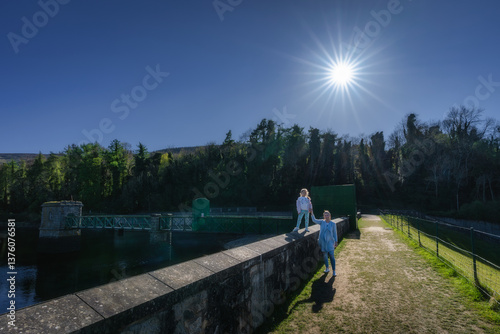 Obraz na płótnie On a bright and sunny day, mother and daughter set out to explore a picturesque reservoir, surrounded by vibrant greenery, tall trees, and a clear blue sky, Bohernabreena Reservoir, Dublin, Ireland w salonie