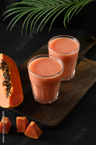 Obraz na płótnie Asian two Papaya lassi, smoothie or tropical cocktails on black background. Summer refreshing beverage of water, fruits and ice. Copy space. w salonie