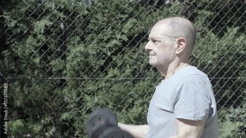 Active Senior Exercising Outdoors with Dumbbells on a Sunny Day