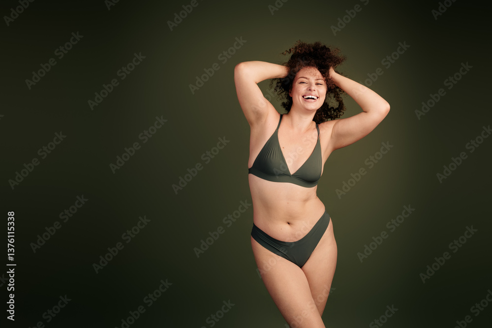 Fototapeta premium Confident young woman in khaki underwear posing against plain background showcasing natural beauty and self acceptance