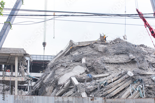 Photography Severe building collapse in Bangkok triggered by a strong earthquake, with visible debris, rubble, and ongoing emergency response efforts