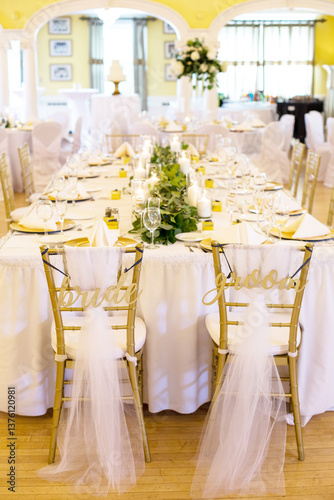 Elegant wedding reception with bride and groom chairs.
