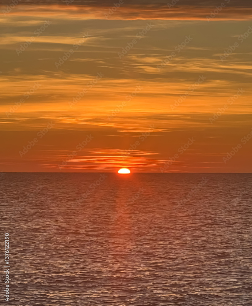 Fototapeta premium Red sun setting over the sea
