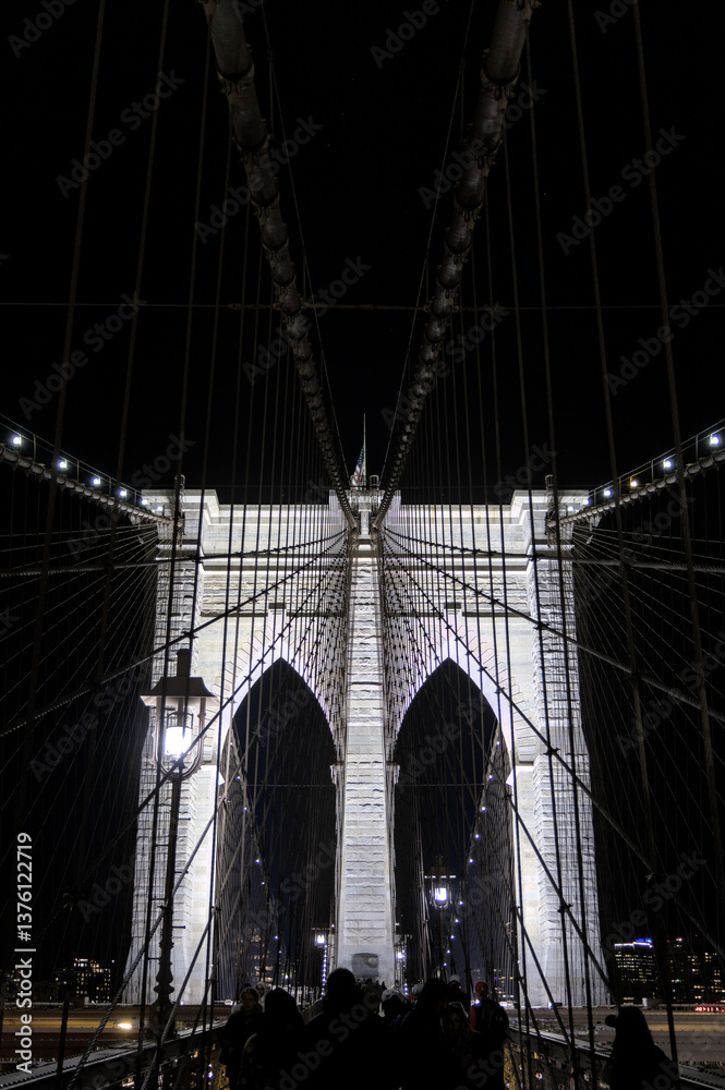 Fototapeta premium brooklyn bridge detail at night (manhattan east river crossing in the dark) illuminated historic landmark monument new york city icon (iconic suspension structure) tourism nightlife travel destination
