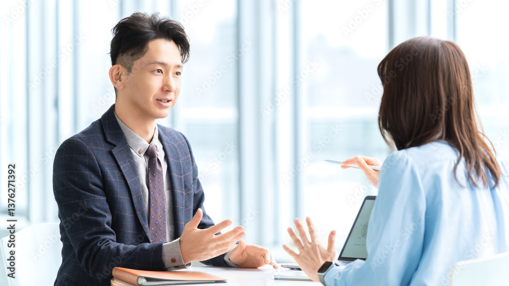 Obraz premium 打ち合わせをする男女2人のビジネスマン