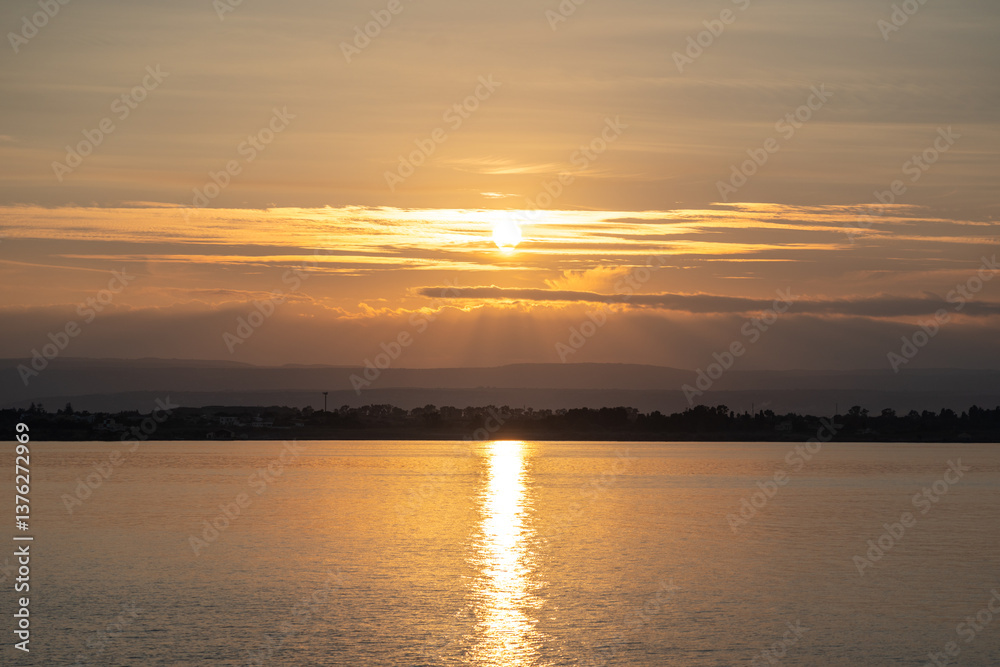 Sunset over the ocean, with the sun low on the horizon, contrast between sky and sea Sunset over the ocean, with the sun low on the horizon, contrast between sky and sea