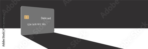 A debit card casts a shadow in this minimalist image with limited color mixed with grey, blacks and whites. 