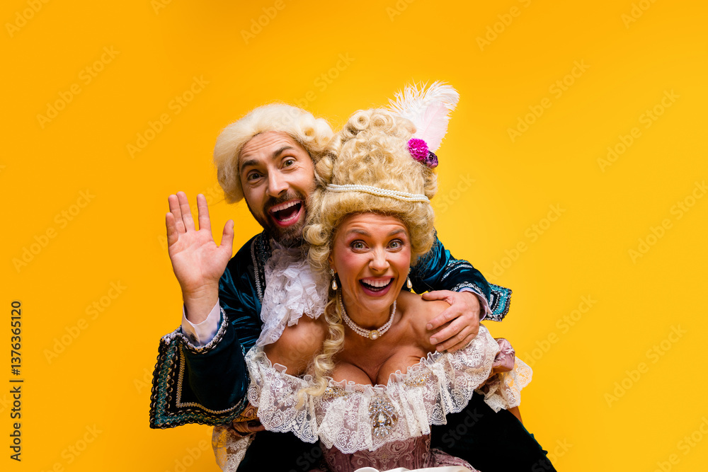 Fototapeta premium Cheerful couple representing aristocratic figures in vibrant costumes against a bright yellow background