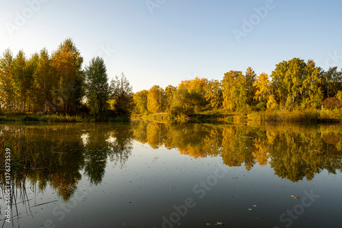 River landscape on a sunny autumn morning. The serenity and tranquility of an autumn morning on the banks of a narrow rural river.