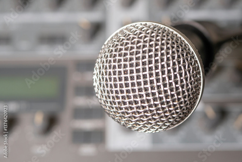 Fotografija Dynamic microphone against the background of a musical synthesizer