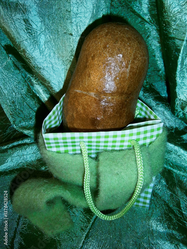 Obraz na płótnie Ein gebackenes Brot zur Dekoration ein einem Beutel vor einem smaragdgrünen Vorhang w salonie