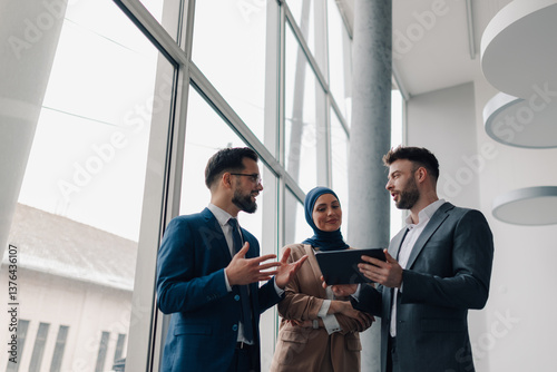 Business people using tablet and discussing in modern office building