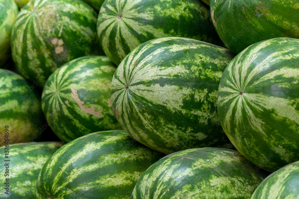 Piles of watermelons displayed in a market. Sample of fresh and ripe fruit. Piles of watermelons displayed in a market. Sample of fresh and ripe fruit.