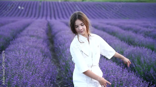 Wallpaper Mural A girl with long hair dances in a field of purple flowers. The scene is serene and peaceful, with the girl's braids blowing in the wind as she walks Torontodigital.ca