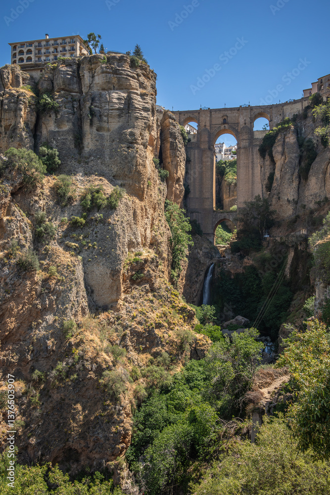 Fototapeta premium Vertical Landscape of Puente Nuevo in Ronda. Beautiful Town on Rock and Bridge during Sunny Day in Spain. Outdoor Andalusian Scenery in Province of Málaga.